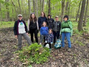 volunteers posing with a pile of garlic mustard